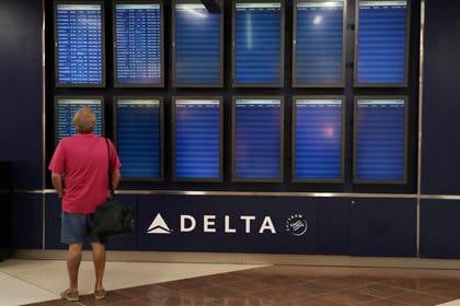 Un hombre mira las pantallas de horarios de vuelo -en su mayoría vacías- en el Aeropuerto Internacional de Atlanta (Reuters)