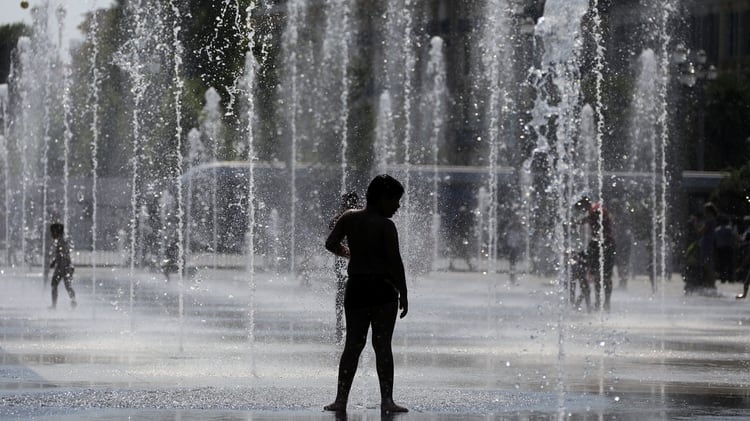 Los niños buscan agua para refrescarse (REUTERS/Eric Gaillard)