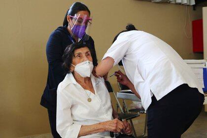 FOTO DE ARCHIVO: Dos trabajadoras sanitarias administran una dosis de la vacuna de AstraZeneca contra la COVID-19 a una anciana en una residencia de Ciudad de México, México, el 17 de febrero de 2021. REUTERS/Henry Romero