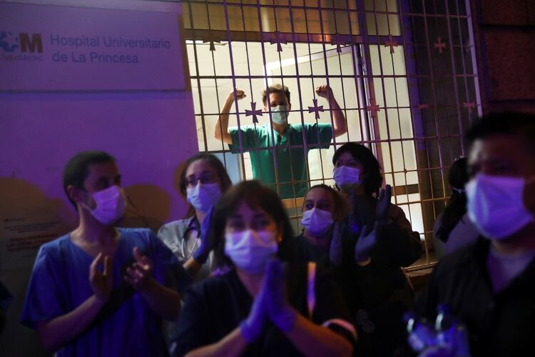 Los trabajadores médicos aplauden para rendir homenaje a todos los profesionales de la salud que están lidiando con el brote de COVID-19, en el hospital La Princesa de Madrid, España, el 25 de marzo de 2020. (REUTERS/Susana Vera)