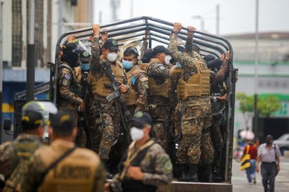 Soldados salvadoreños esperan a ser transportados mientras custodian el cumplimiento de la cuarentena en San Salvador (REUTERS/Jose Cabezas)