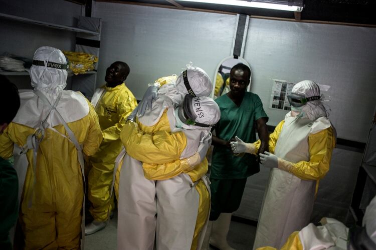 Trabajadore sde la salud se calzan los trajes de protección antes de partir a una de la zonas más afectadas por el brote de ébola (John WESSELS / AFP)