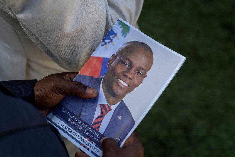 Una persona sostiene una foto del fallecido presidente haitiano Jovenel Moise, que fue asesinado a principios de este mes, durante su funeral en su casa familiar en Cabo Haitiano, Haití. 23 de julio de 2021 (REUTERS/Ricardo Arduengo)