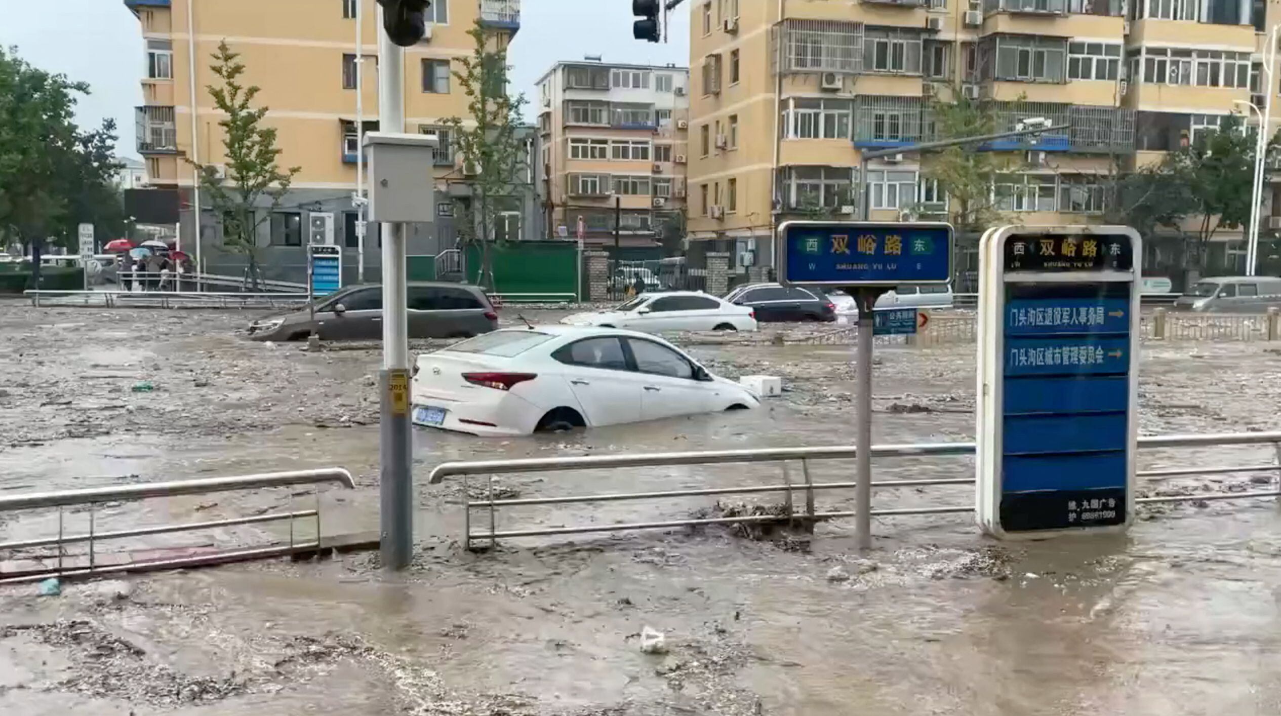 Autos parcialmente sumergidos en Beijing (via Reuters)