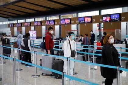 Un pasajero con un traje de protección hace cola en el aeropuerto de Estambul durante el primer día de reanudación de vuelos nacionales que se suspendieron el 26 de marzo en medio de la pandemia de coronavirus este 1 de junio (Reuters)