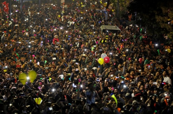 La gente enciende sus teléfonos móviles mientras celebra la cuenta atrás del Año Nuevo en una carretera de Ahmedabad, India (REUTERS/Amit Dave)