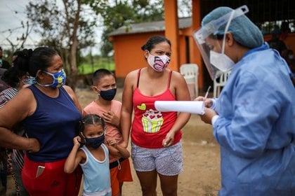Un miembro del equipo médico de la Cruz Roja Colombiana habla con refugiados venezolanos dentro de una escuela que sirve de refugio para los desplazados venezolanos en Arauquita, Colombia, 28 de marzo, 2021. REUTERS/Luisa González