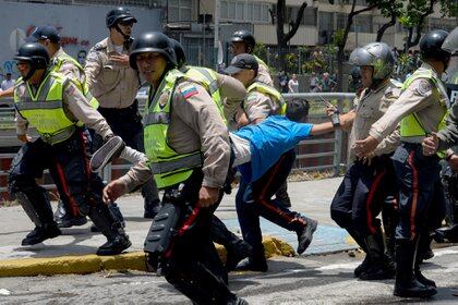 FOTO DE ARCHIVO: Policía del régimen chavista en Venezuela arresta a un manifestante durante una protesta contra Nicolás Maduro en Caracas el 4 de abril de 2017 (AFP / FEDERICO PARRA)