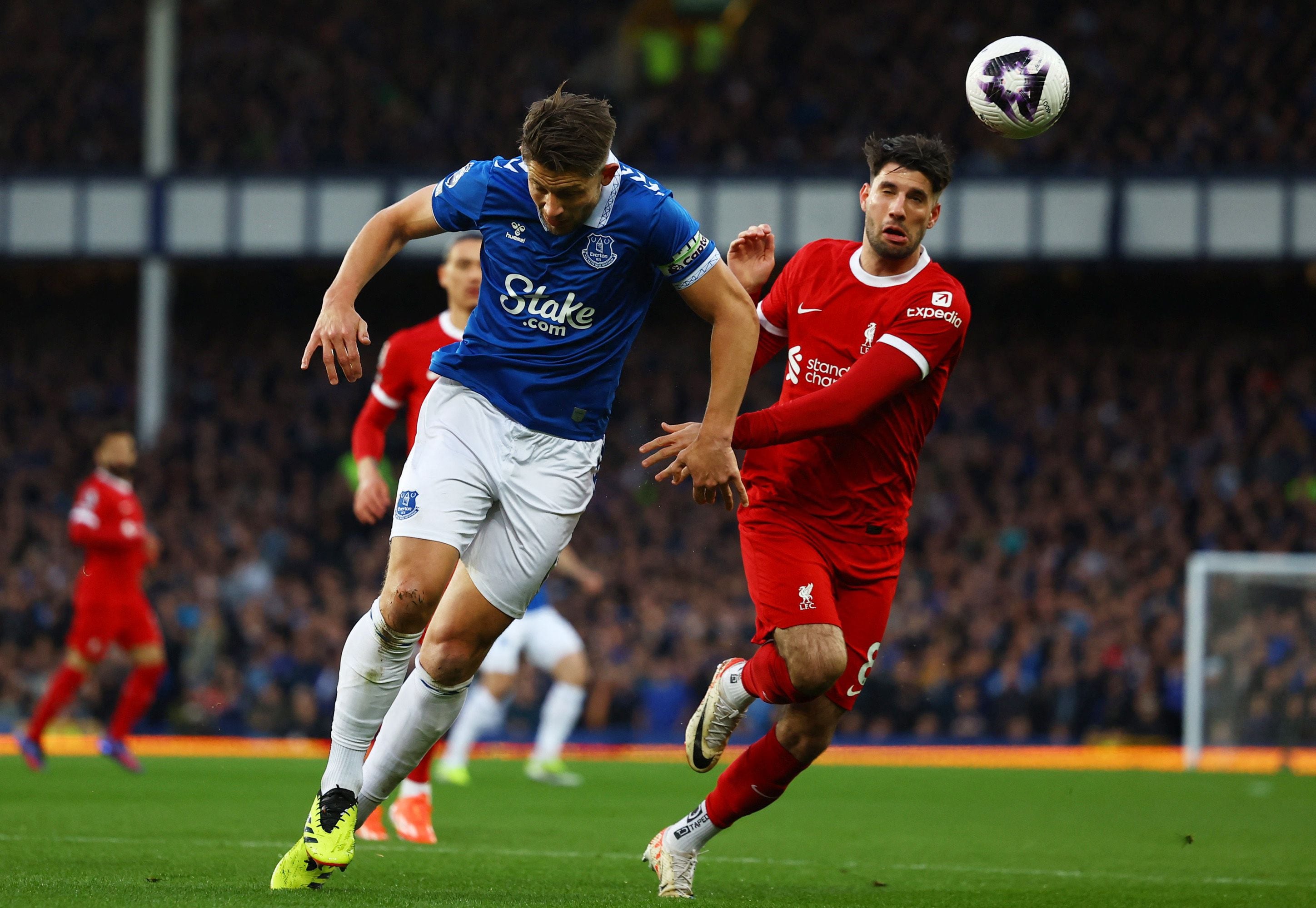 Fútbol - Liga Premier - Everton v Liverpool - Goodison Park, Liverpool, Bretaña - abril 24, 2024 Everton's James Tarkowski in action with Liverpool's Dominik Szoboszlai Action Images via Reuters/Lee Smith NO USE WITH UNAUTHORIZED AUDIO, VÍDEO, DATA, FIXTURE LISTS, CLUB/LEAGUE LOGOS OR 'LIVE' SERVICES. ONLINE IN-MATCH USE LIMITED TO 45 IMAGES, NO VIDEO EMULATION. NO USE IN BETTING, GAMES OR SINGLE CLUB/LEAGUE/PLAYER PUBLICATIONS.