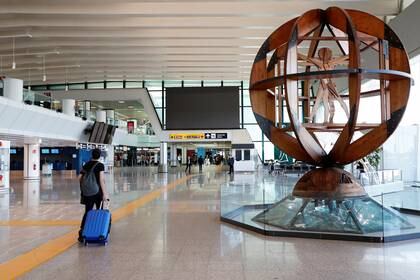 Un pasajero empuja su equipaje en el aeropuerto de Fiumicino, después de que Italia comenzara gradualmente el cierre nacional debido a la enfermedad por coronavirus (COVID-19), en Roma, Italia, 6 de mayo de 2020. (REUTERS / Remo Casilli)