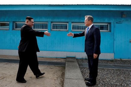 El presidente de Corea del Sur, Moon Jae-in, y el líder de Corea del Norte, Kim Jong Un, se dan la mano en la aldea de Panmunjom, en una zona desmilitarizada que separa las dos Coreas, Corea del Sur, el 27 de abril de 2018. Servicio de Pool de Prensa de la Cumbre de Corea a través de Reuters