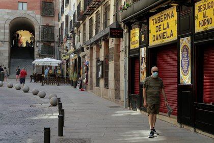 A man wearing a protective mask walks past a closed bar, amid the coronavirus disease (COVID-19) outbreak, in Madrid, Spain, July 31, 2020. REUTERS/Javier Barbancho
