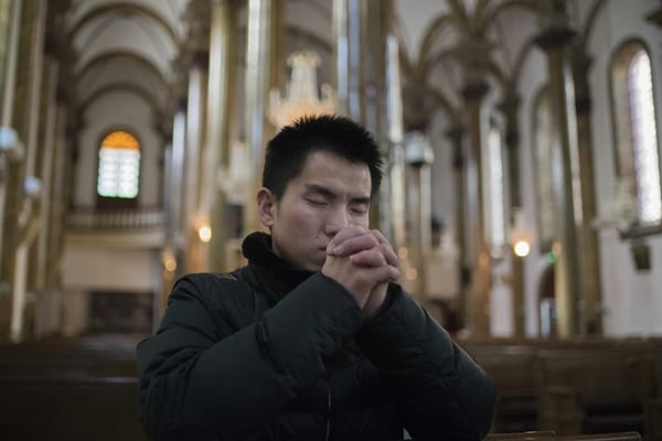 Un hombre rezando en Wangfujing (AFP)