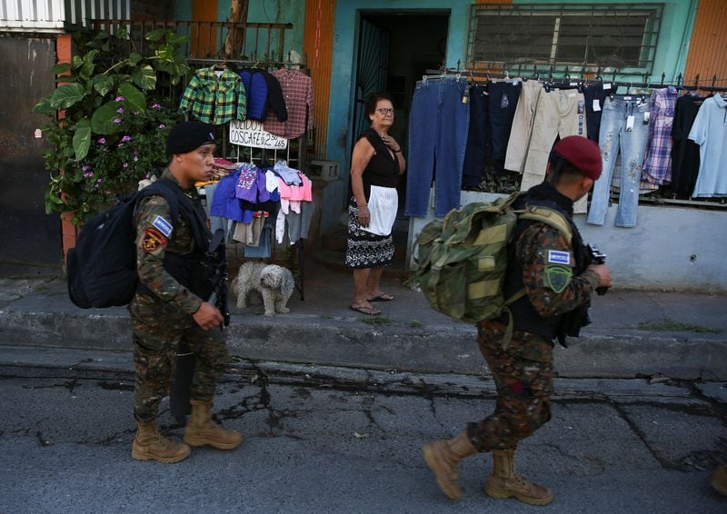 Una mujer mira a las tropas que pasan frente a su tienda en el suburbio salvadoreño Soyapango (REUTERS/José Cabezas)
