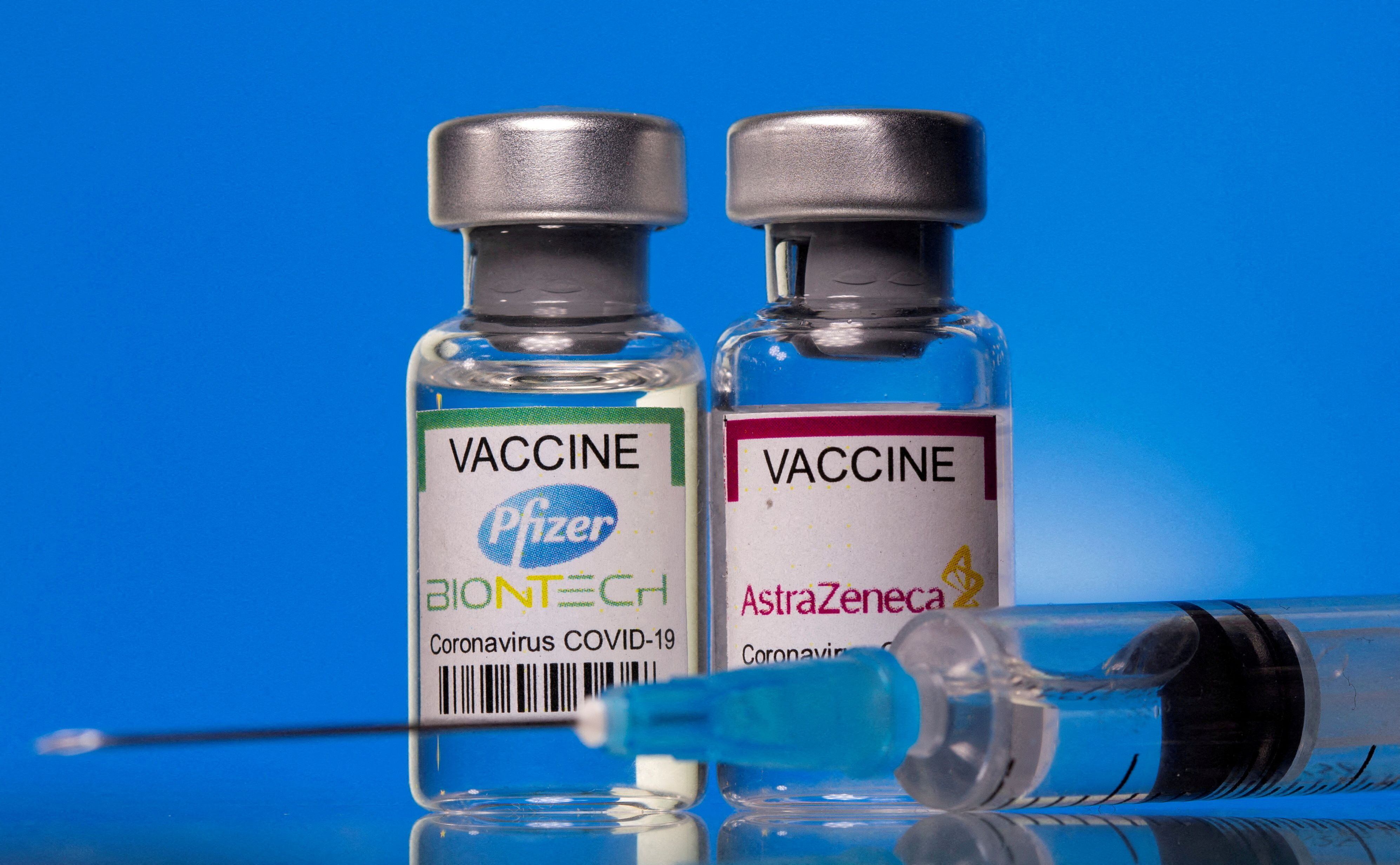 FILE PHOTO: Vials with Pfizer-BioNTech and AstraZeneca COVID-19 vaccine labels are seen in this illustration picture taken March 19, 2021. REUTERS/  REUTERS/Dado Ruvic/Illustration/File Photo