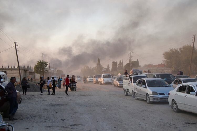 Sirios huyendo del bombardeo de fuerzas turcas en Ras al Ayn, nordeste de Siria, este miércoles 9 de octubre (AP)