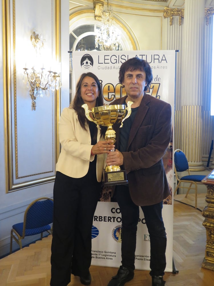La directora del certamen, la maestra Elisa Maggiolo, le entrega el trofeo a GarcÃ­a Palermo en la Legislatura porteÃ±a.