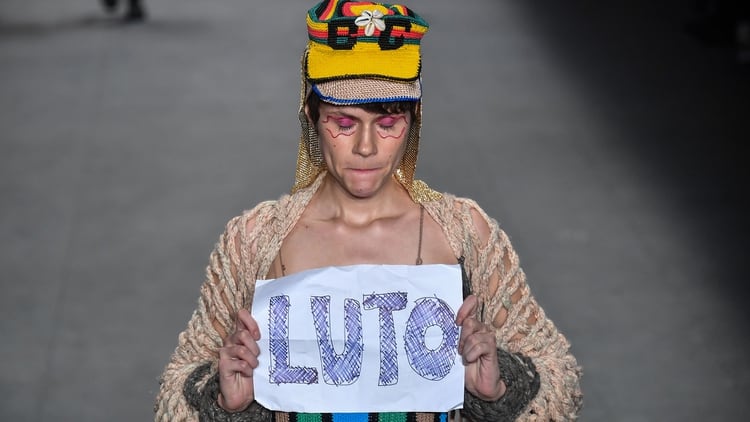 Una modelo sostiene un cartel con la palabra luto por la muerte del modelo brasileño Tales Cotta, durante la Semana de la Moda de San Paulo este sábado.
