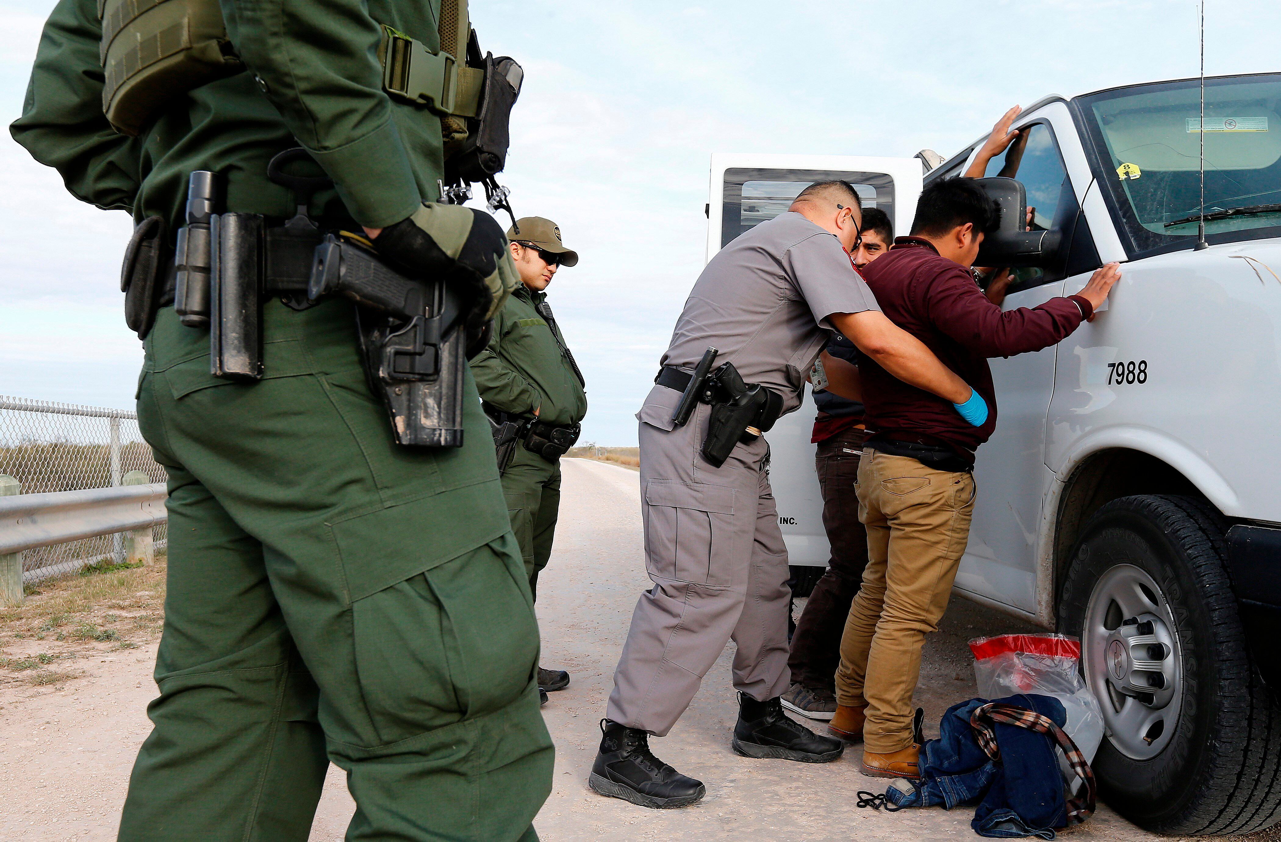 Guardias estadounidenses de la Patrulla de Fronteras deteniendo a uno de los inmigrantes que trataba de pasar la frontera de forma ilegal. (EFE/ Erik S. Lesser)
