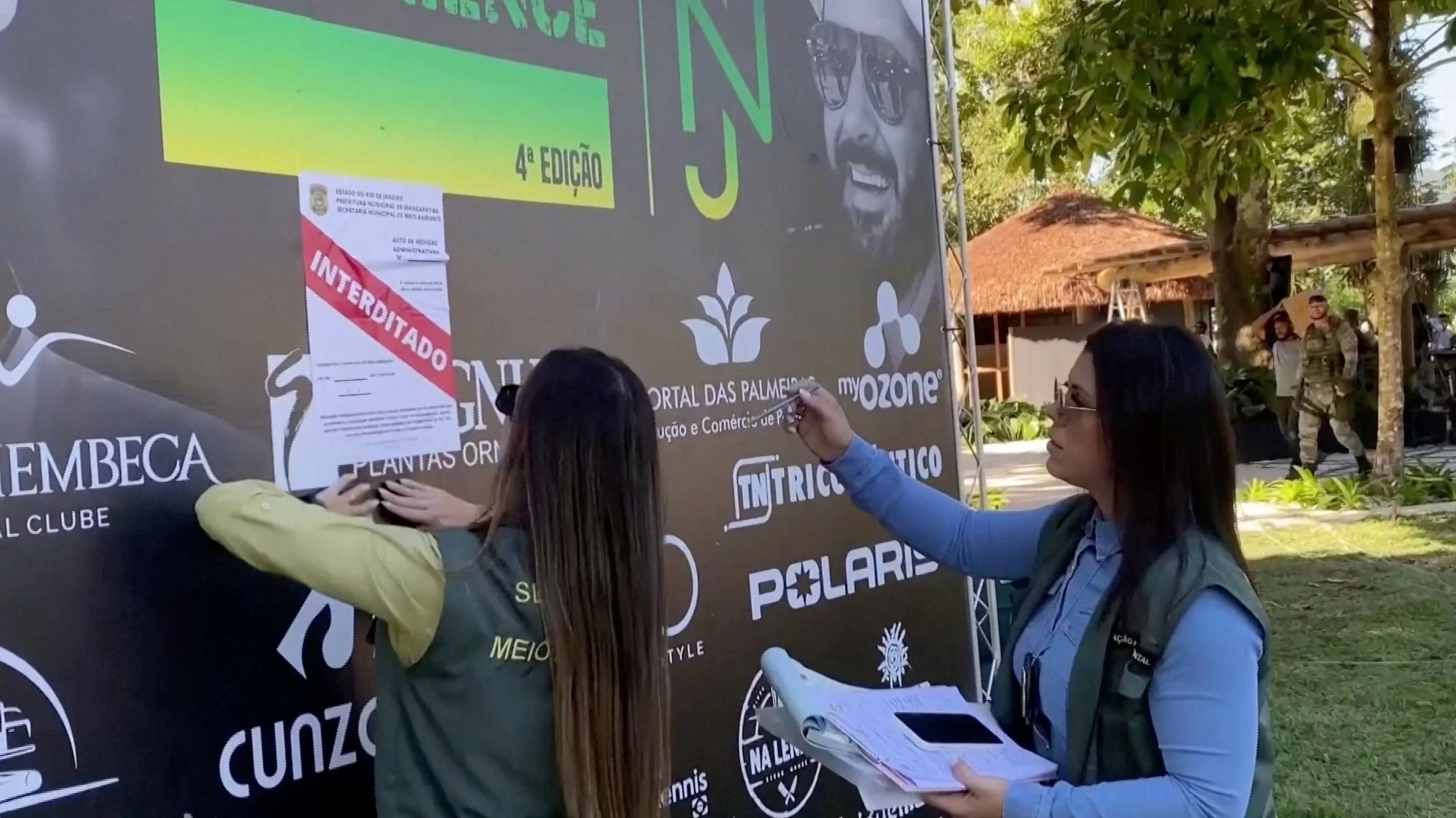 Un funcionario coloca un cartel de "Interdicto" mientras se detiene una construcción en una propiedad de la estrella del fútbol brasileño Neymar Jr. por violaciones ambientales, en Mangaratiba, Brasil, el 22 de junio de 2023 (Departamento de Medio Ambiente de Mangarativa/Folleto a través de REUTERS)