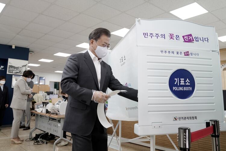 El presidente de Corea del Sur, Moon Jae-in, con una máscara y unos guantes de plástico para prevenir el contagio de coronavirus, llega para emitir su voto en ausencia en un colegio electoral para las elecciones parlamentarias en Seúl, el 10 de abril de 2020. (Yonhap vía REUTERS)