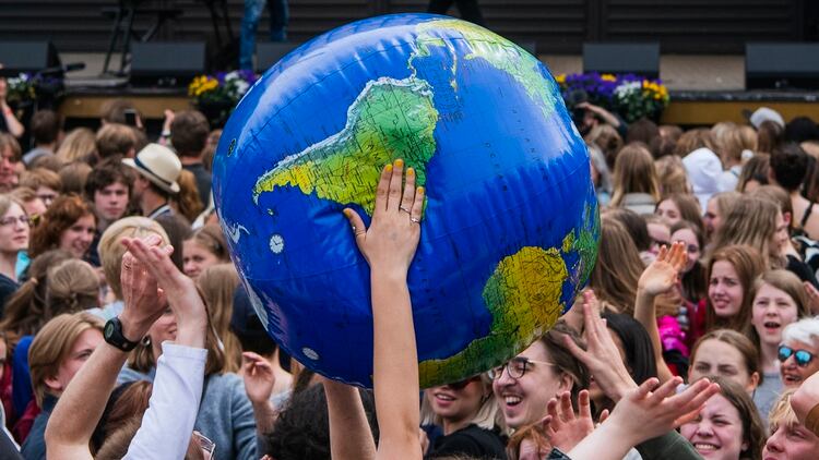 Los manifestantes lanzan un globo de la Tierra durante la manifestación “Huelga Global por el Futuro” en Estocolmo el 24 de mayo de 2019, un día mundial de protestas estudiantiles con el objetivo de incitar a los líderes mundiales a actuar sobre el cambio climático. (AFP)