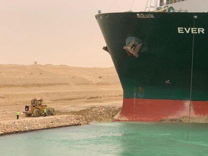 Trabajadores junto a un buque portacontenedores que fue golpeado por un fuerte viento y encalló en el Canal de Suez, Egipto. 24 de marzo de 2021. Autoridad del Canal de Suez/Handout vía REUTERS