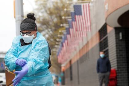 Una técnica de emergencias (EMT) se pone el equipo de protección personal antes de ir al Hospital Elmhurst durante el brote de coronavirus en el barrio de Queens de Nueva York, EE.UU., el 20 de abril de 2020. (REUTERS/Lucas Jackson/Foto de archivo)
