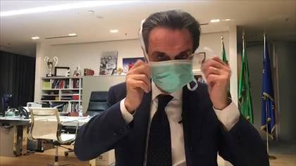 El gobernador de Lombardía, Attilio Fontana, se pone una máscara protectora mientras habla en Facebook (Facebook Live/REUTERS TV)