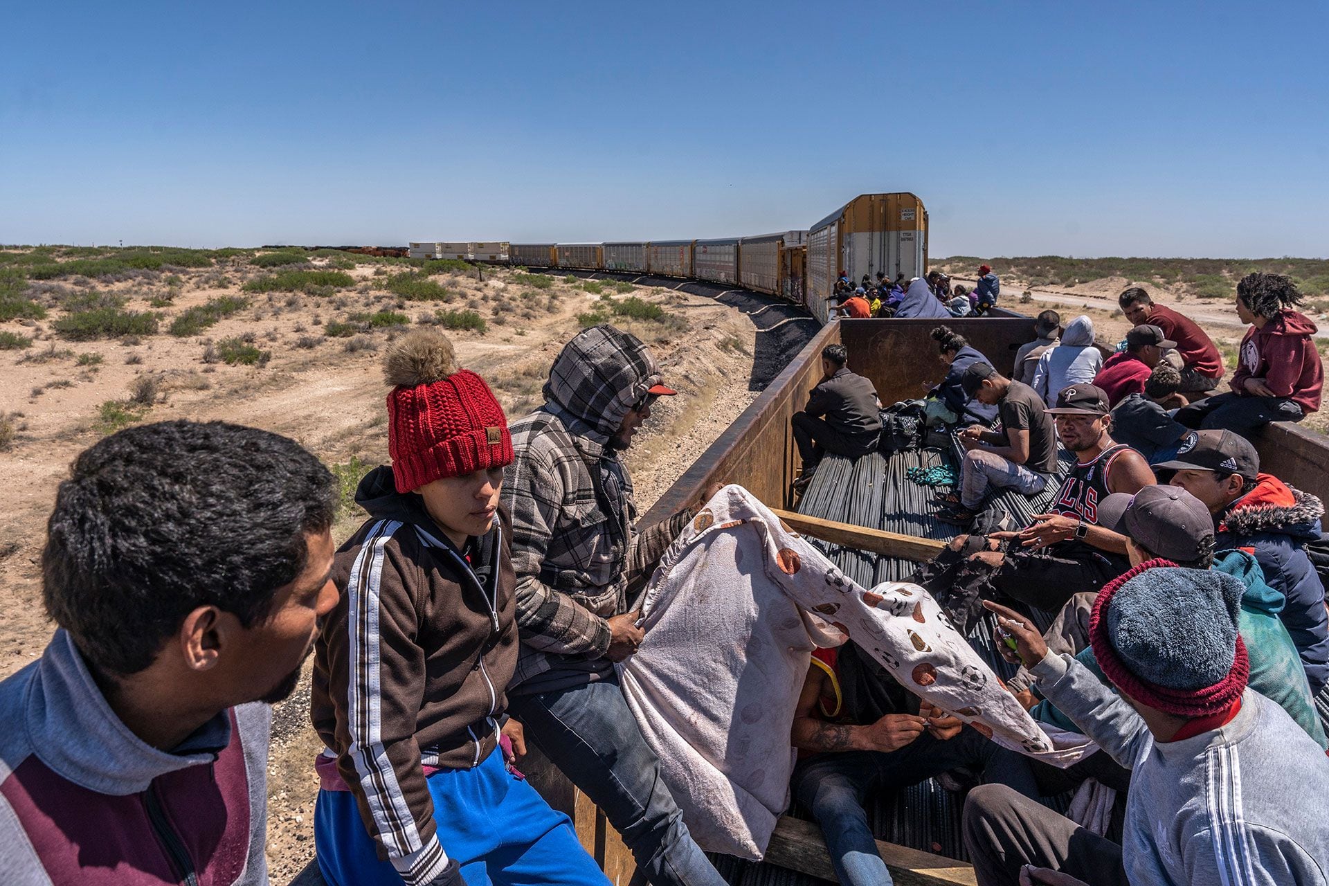 Un grupo de inmigrantes venezolanos a bordo de un tren de carga que se dirije hacia Ciudad Juárez, en la frontera con Estados Unidos. (Alejandro Cegarra/The New York Times)