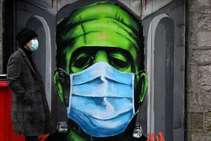 Un hombre pasa por delante de un graffiti de un Frankenstein que lleva una mascarilla durante  la propagación de la pandemia de la enfermedad coronavirus, en Galway, Irlanda (REUTERS/Clodagh Kilcoyne)