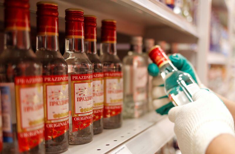 Un empleado de un supermecado en Moscú coloca botellas de vodka en los estantes en medio del alto consumo de alcohol en el país detectado por la pandemia. April 8, 2020. REUTERS/Maxim Shemetov