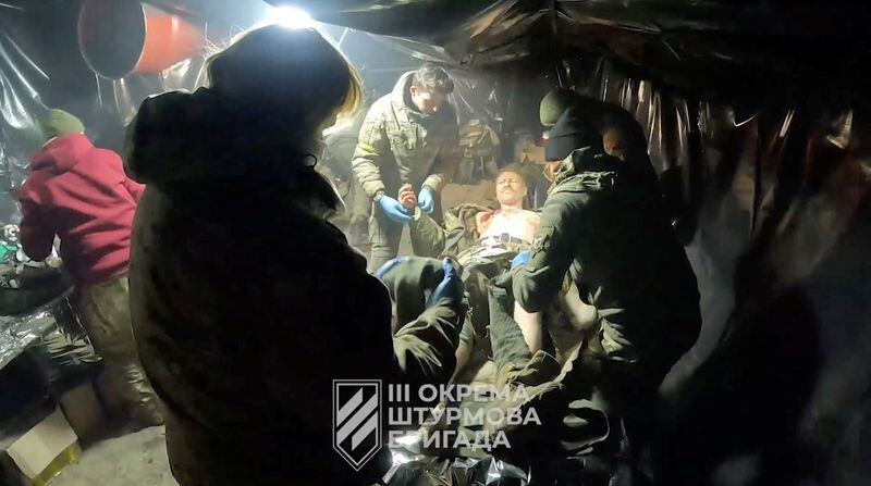 Un soldado ucraniano herido recibe ayuda en Avdivka (3ª Brigada de Asalto/REUTERS)