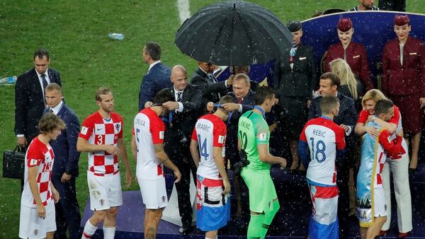 Un hombre protege a Putin de la lluvia mientras el resto se empapa (Reuters)