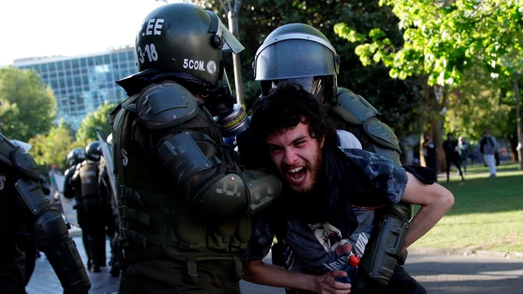 Dos agentes retienen a un joven (Reuters)