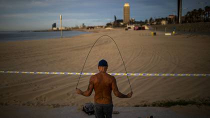 Un hombre hace ejercicio en la playa (AP Photo/Emilio Morenatti)