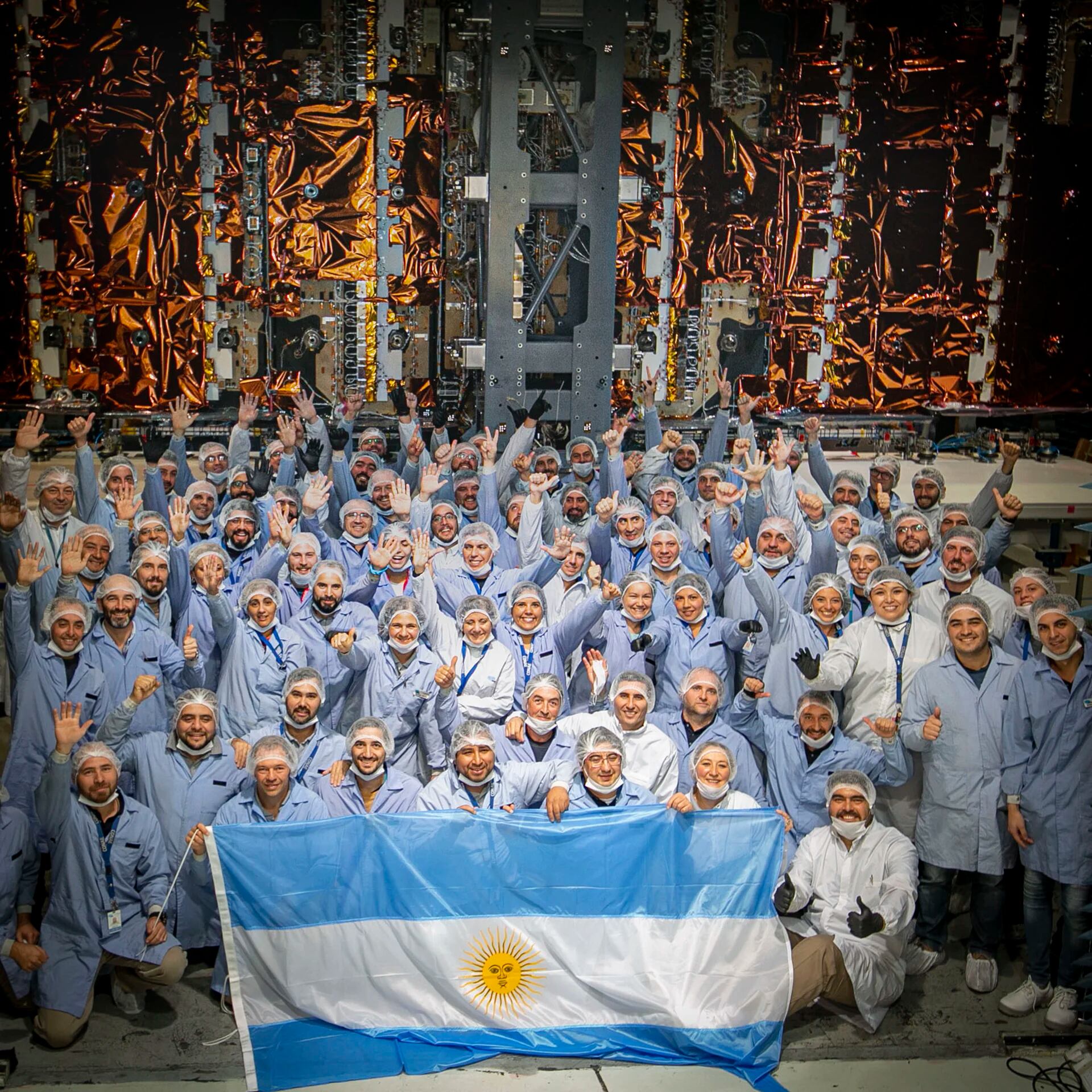 Los ingenieros argentinos posan orgulloso con el satélite ya construido (Conae)