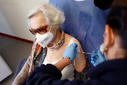 Una mujer recibe la primera dosis de la vacuna de Pfizer-BioNTech en Roma, Italia (REUTERS/Guglielmo Mangiapane)
