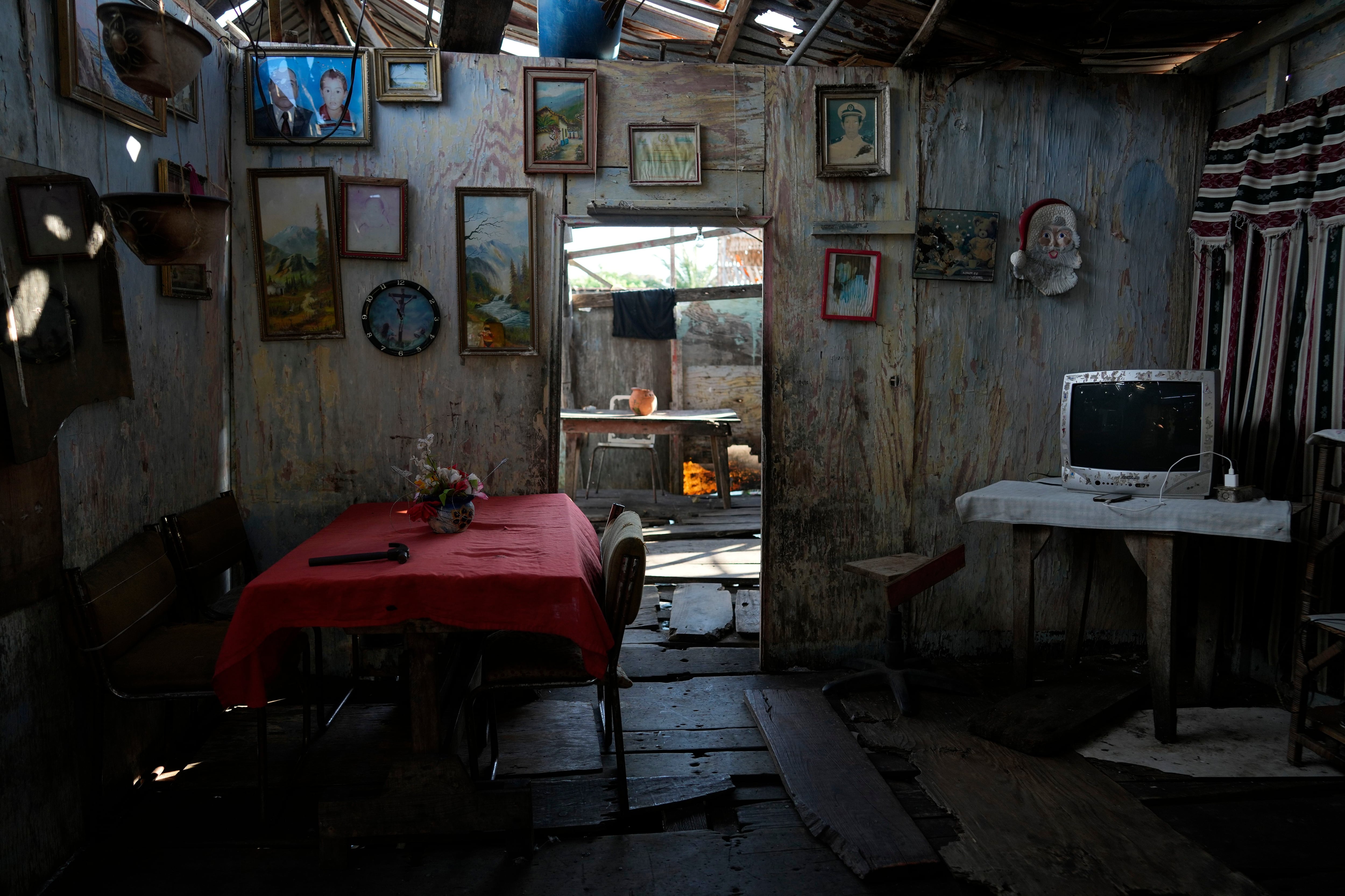 Retratos de familia y cuadros adornan las paredes de una casa sobre pilones que se asienta en la orilla del lago   (AP Foto/Ariana Cubillos)