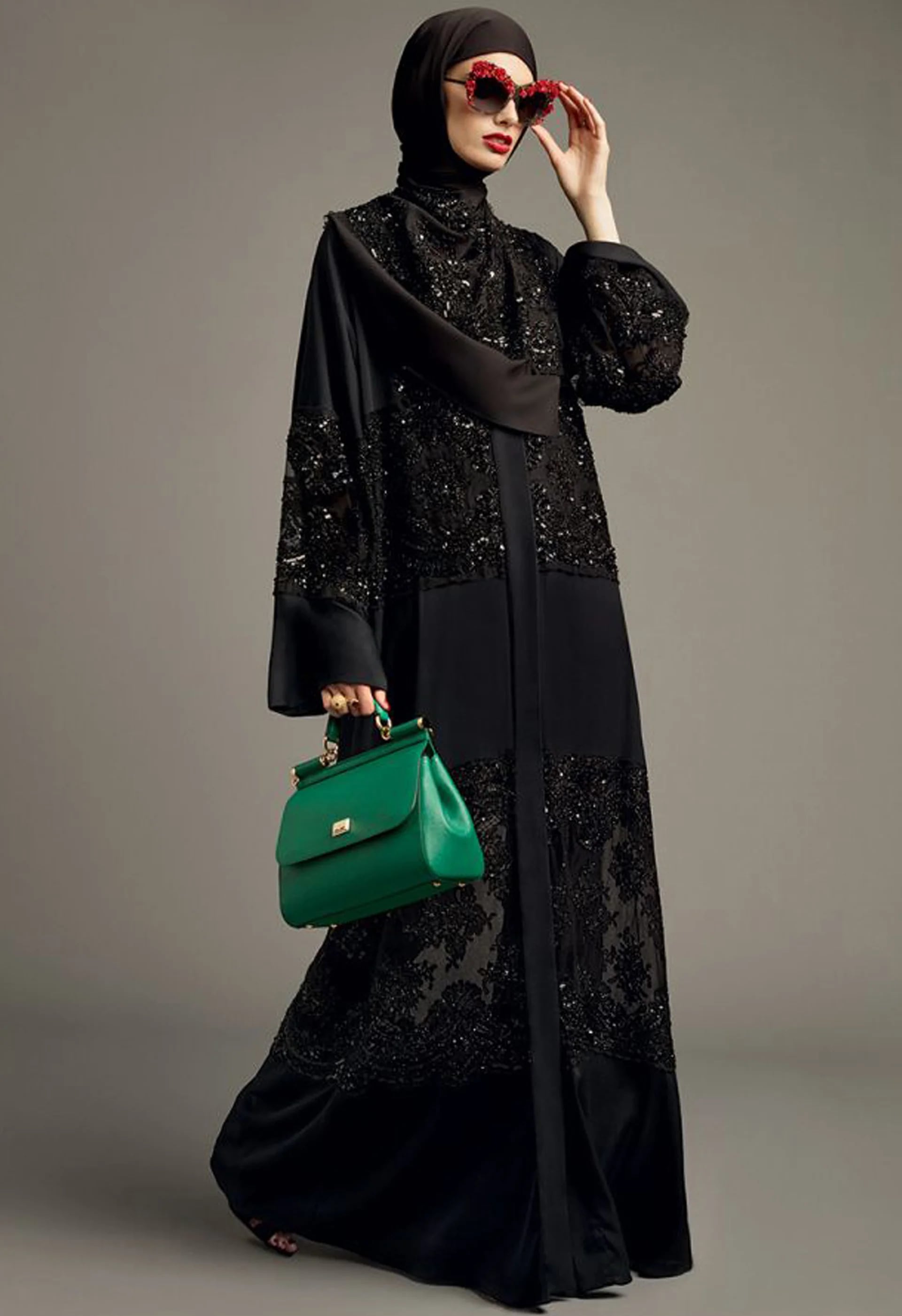 Con transparencias y bordado en total black y detalles de color en los anteojos y la cartera verde esmeralda ‘Sicily’ (Vogue Arabia)