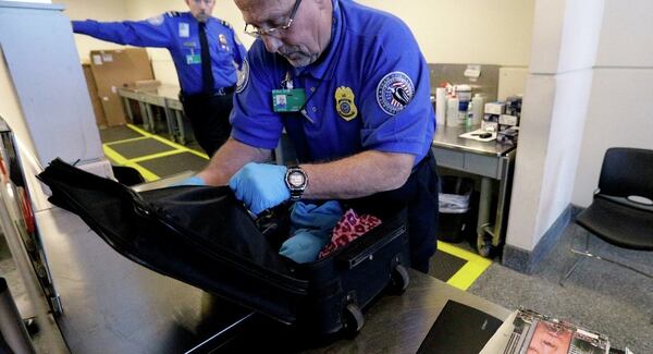 Un oficial de la Administración de Seguridad del Transporte (TSA por sus siglas en inglés) de Estados Unidos registra una maleta en un control aeroportuario (AP/Nam Y. Huh)