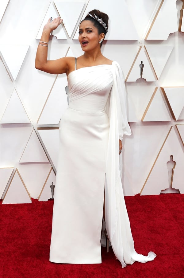 Apostando a un diseño total white con detalles de bretel finito de cristales, la actriz Salma Hayek, eligió a Gucci para la entrega de los Oscars. Un modelo de un solo hombro y con detalles de drapeado en la parte superior de la pieza 