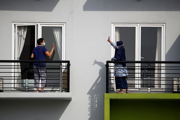 Pacientes se saludan desde sus balcones en un centro de capacitación, que se ha convertido en una casa de cuarentena, en Tangerang, en las afueras de Yakarta, Indonesia, en medio del brote de coronavirus (Reuters)