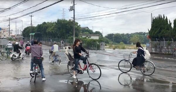 Personas en bici sobre una calle daÃ±ada en Osaka (@tw_hds via REUTERS)
