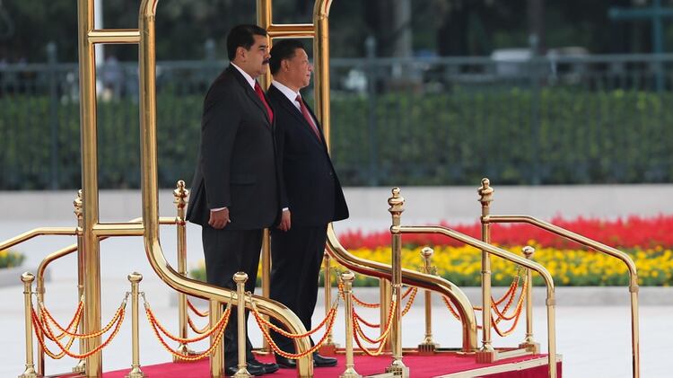 Foto tomada y publicada por la Presidencia venezolana el 14 de septiembre de 2018 que muestra al presidente venezolano Nicolás Maduro (izq.) y a su homólogo chino Xi Jinping de pie en un podio mientras escuchan sus himnos nacionales durante la ceremonia de bienvenida en Beijing (AFP)