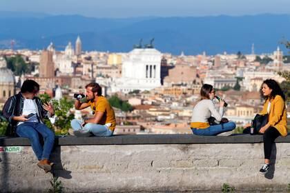 La gente disfruta de las bebidas en la colina del Gianicolo, en medio del brote de coronavirus en Roma, Italia, el 8 de mayo de 2020. (REUTERS/Guglielmo Mangiapane)