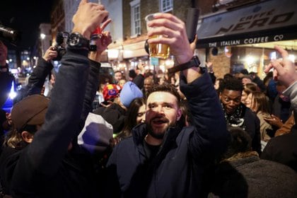 La gente sostiene bebidas mientras celebra en una calle del Soho. Londres, Gran Bretaña, el 12 de abril de 2021. REUTERS / Henry Nicholls
