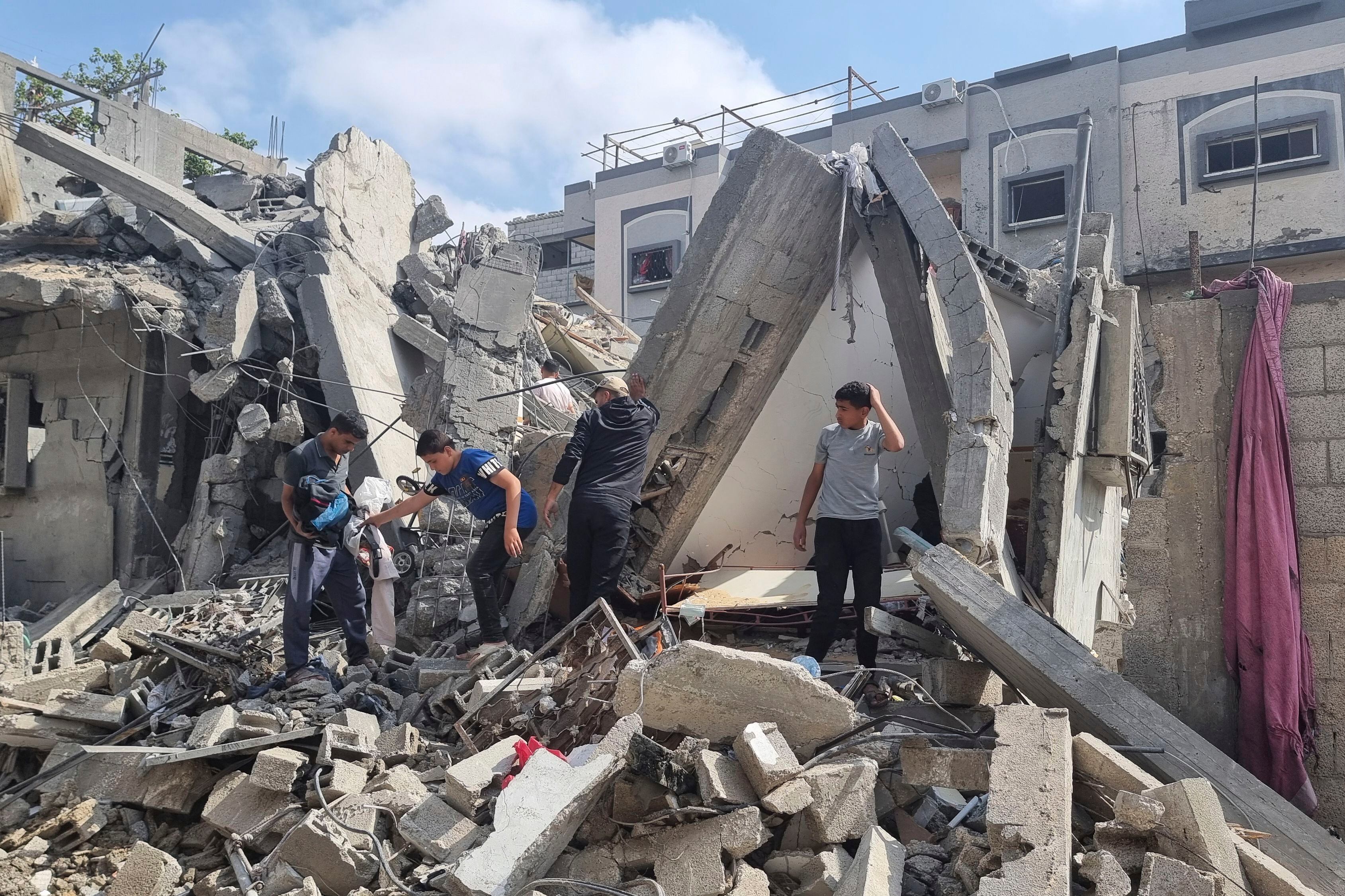 Palestinos buscan entre los escombros de una vivienda tras un ataque aéreo israelí en Rafah (AP Foto/Mohammad Jahjouh)