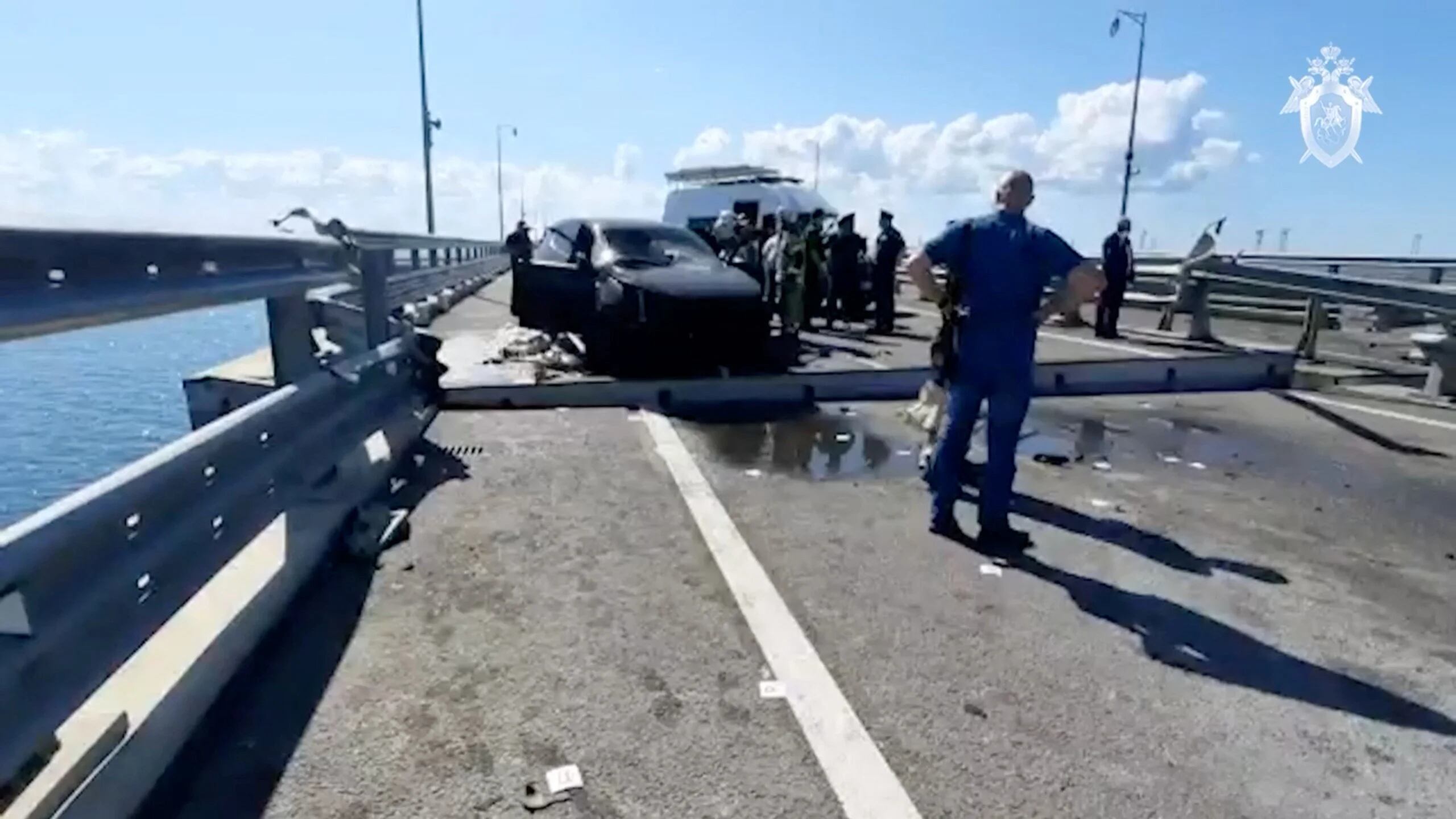 Investigadores y personal de emergencia junto a un auto destruido en el ataque (via Reuters)