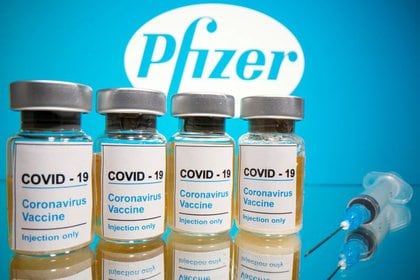 Fotografía tomada  el 31 de octubre de 2020 en la que se ven frascos con etiquetas que dicen "COVID-19/Vacuna contra el coronavirus/Solo inyección" y una jeringa médica frente al logotipo de Pfizer. (REUTERS/Dado Ruvic)